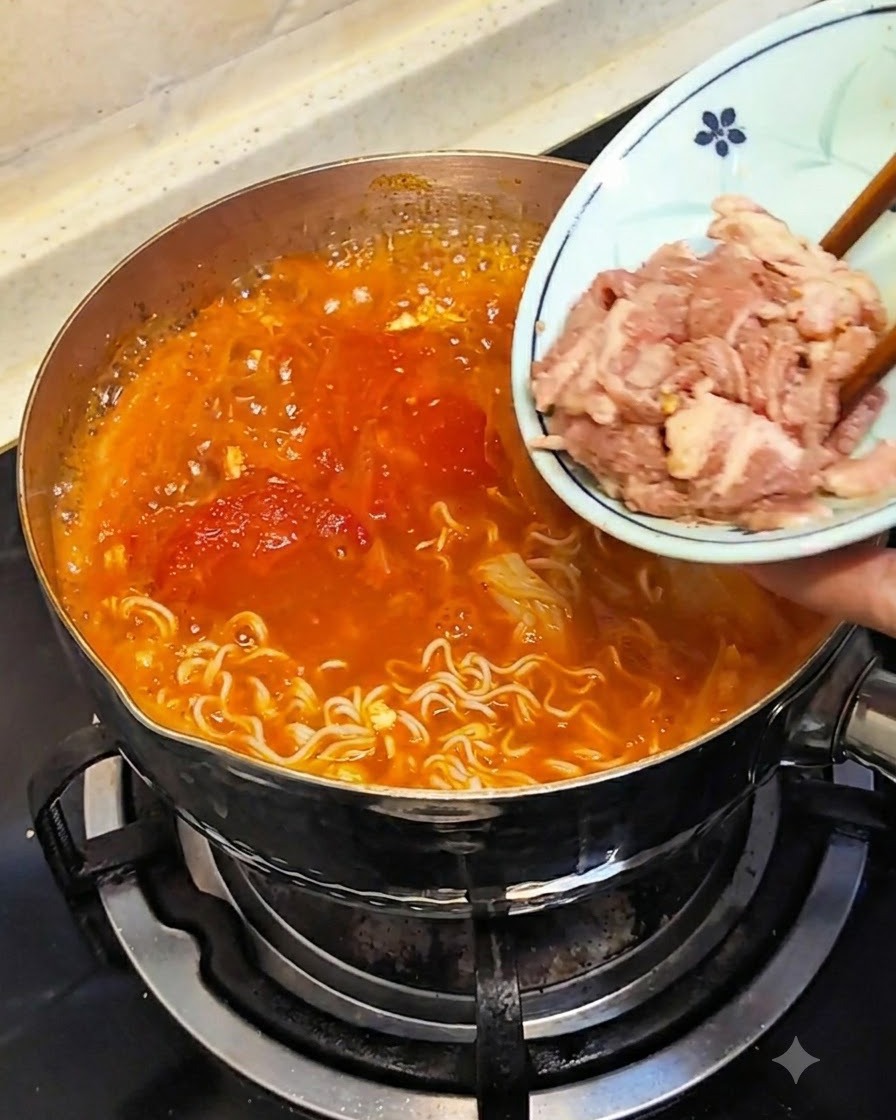Palillos sumergiendo carne cruda cortada finamente desde un plato pequeño en el caldo caliente.