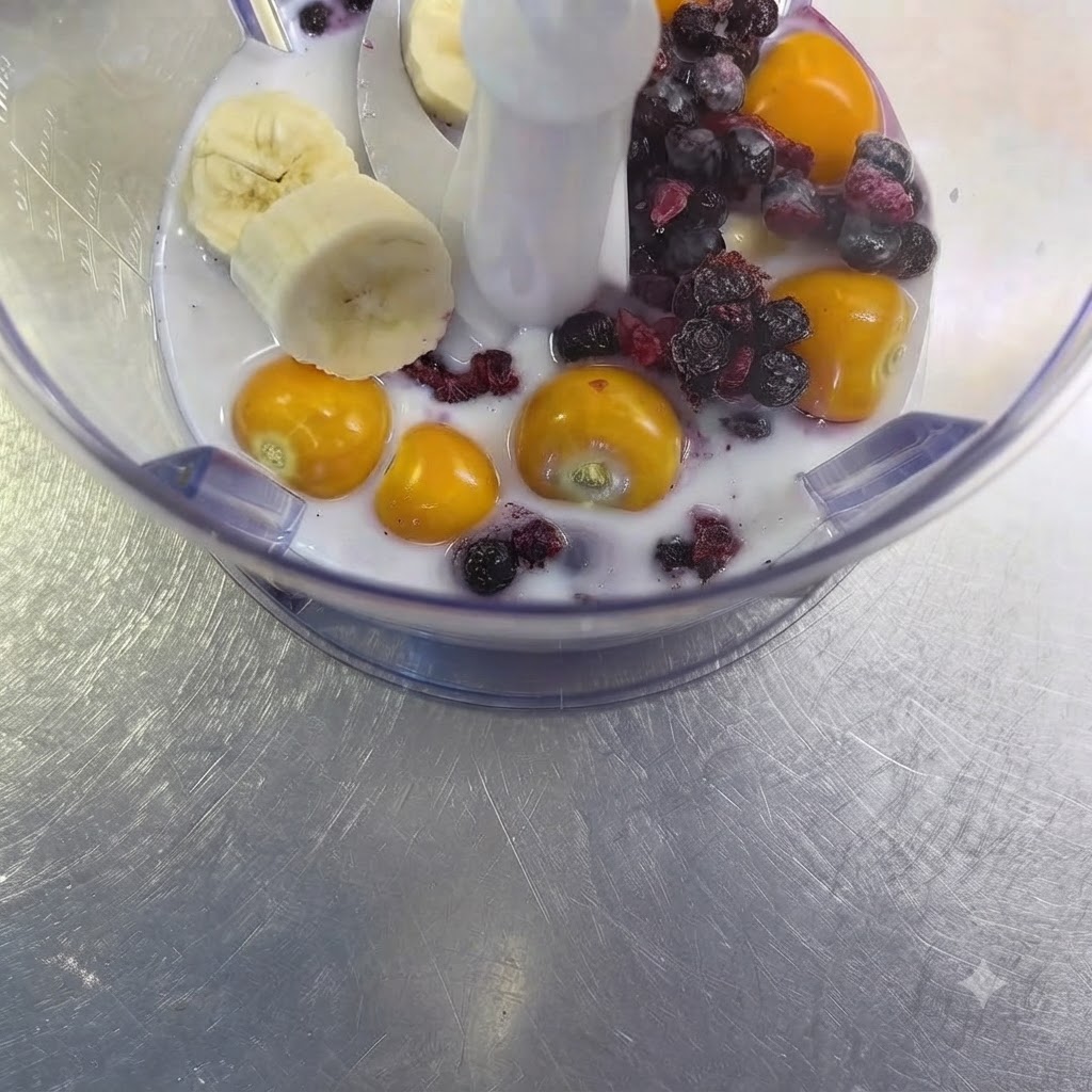 Un diente de ajo crudo colocado entre la mezcla de fruta y leche dentro del vaso de la licuadora.