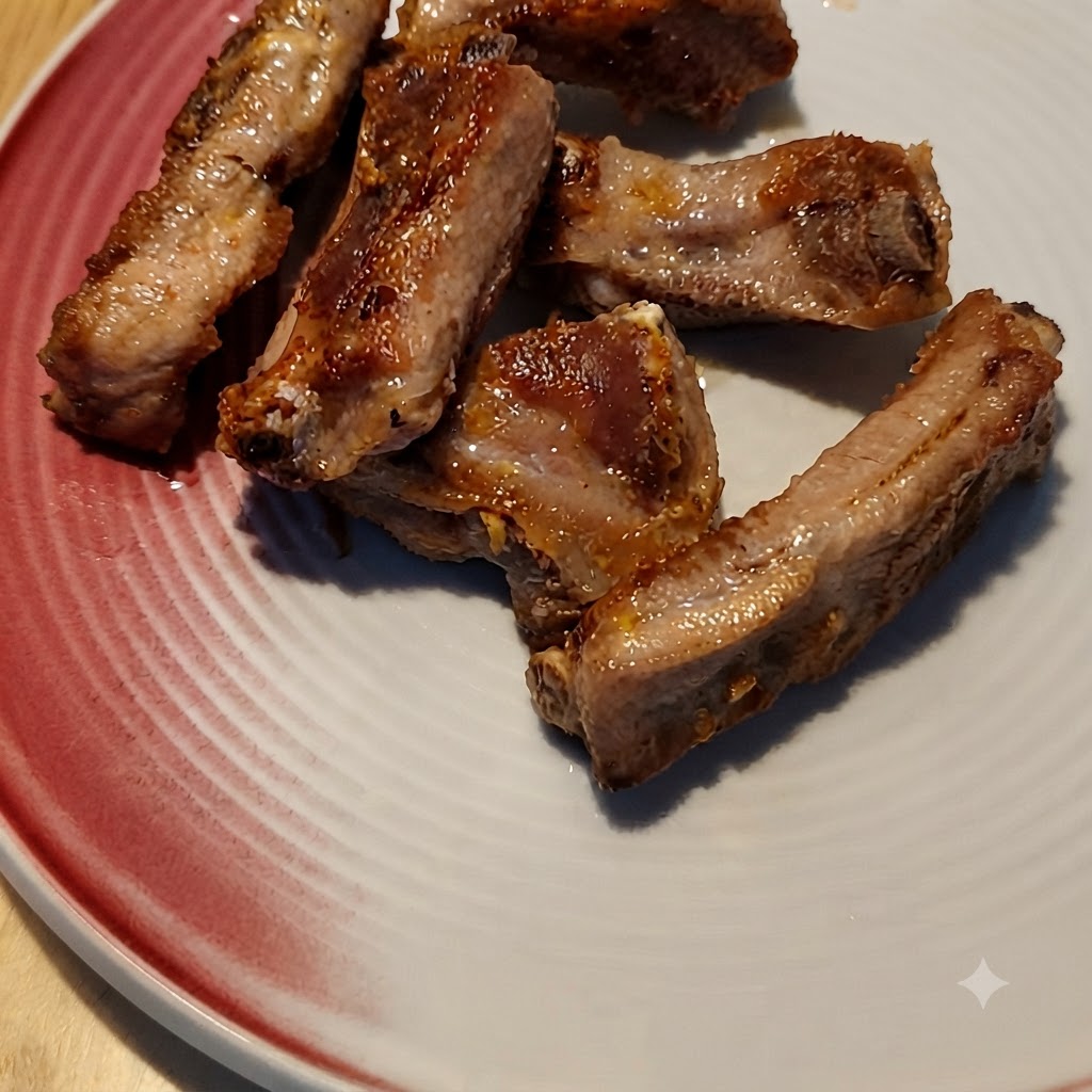 Salsa de café siendo vertida sobre costillas de cerdo doradas en una sartén.