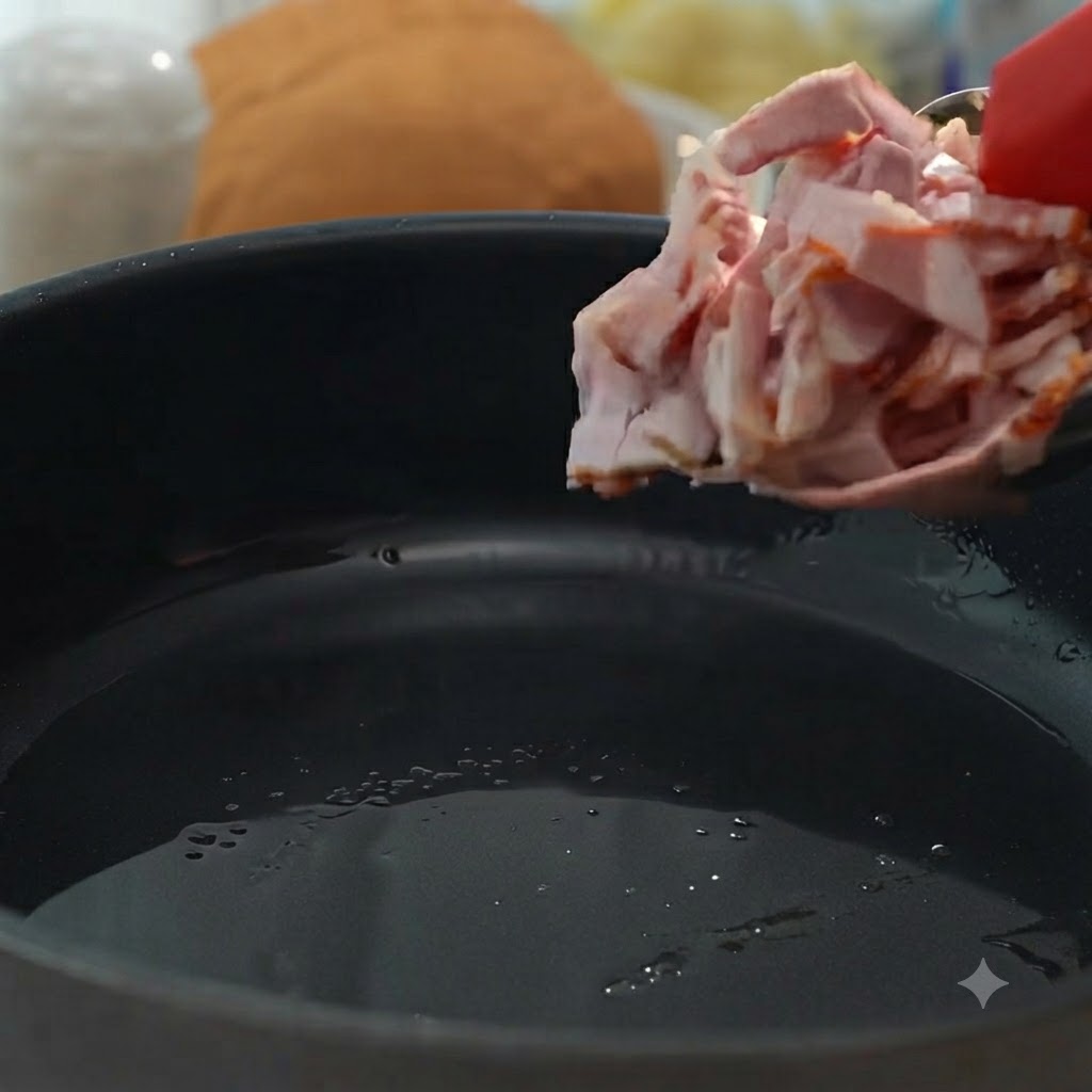Trozos de tocino siendo agregados a una sartén para freírse hasta quedar crujientes y dorados.