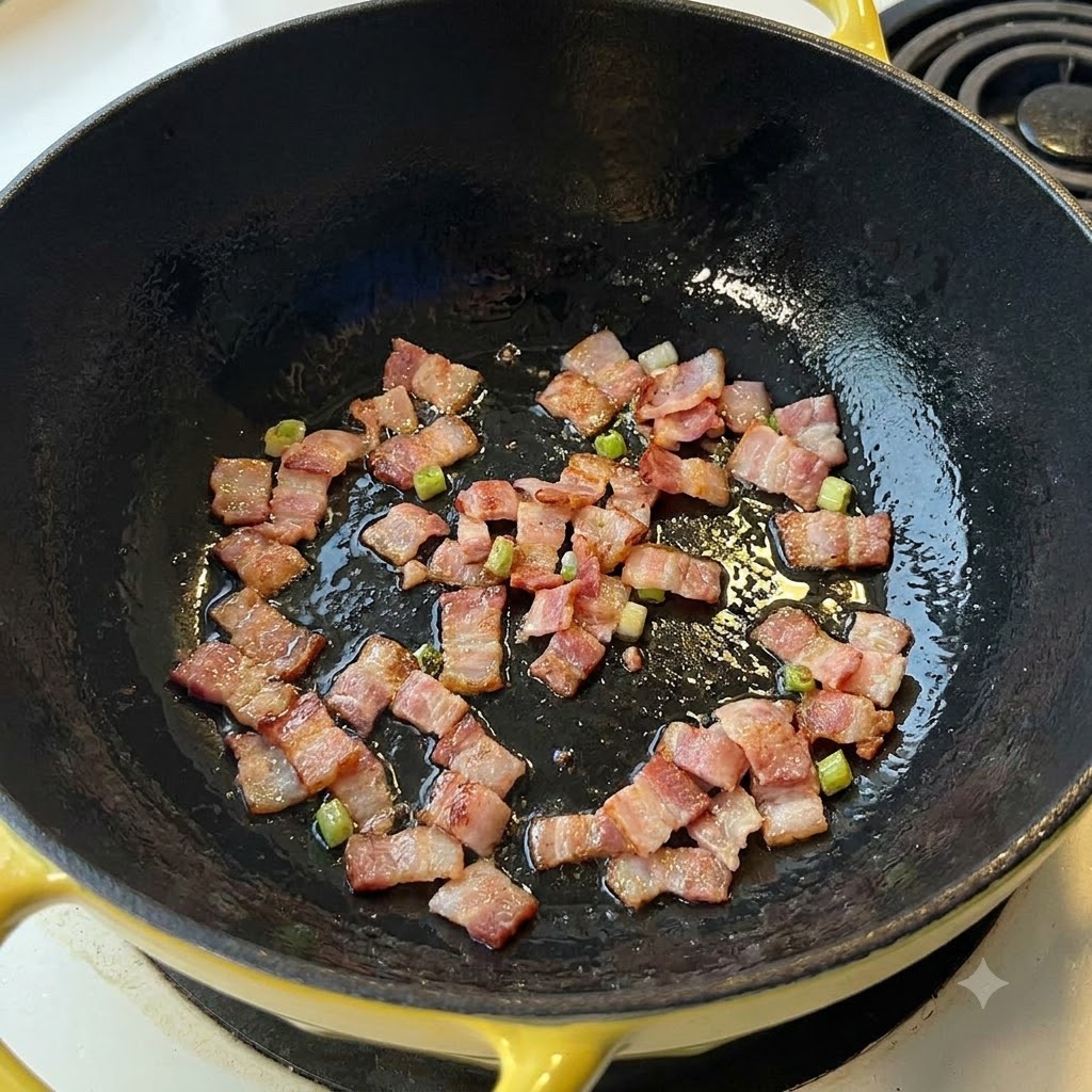 Trozos de tocino chisporroteando y friéndose en una sartén oscura.