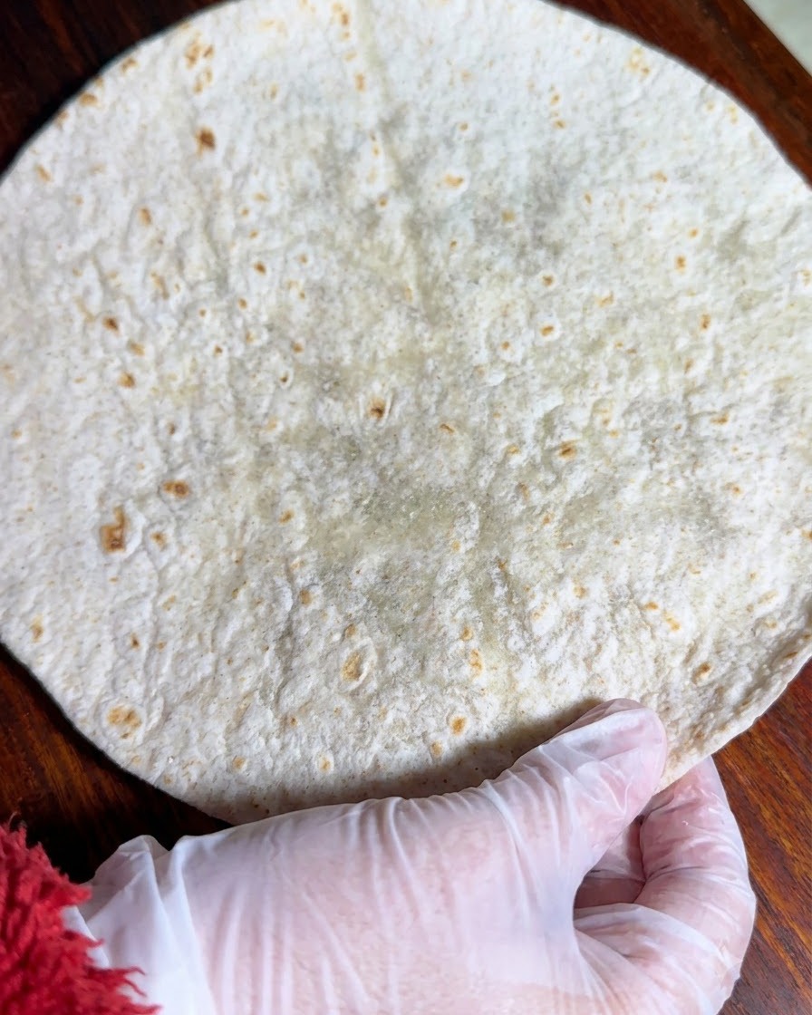 Una tortilla integral extendida de manera plana sobre una superficie de madera.