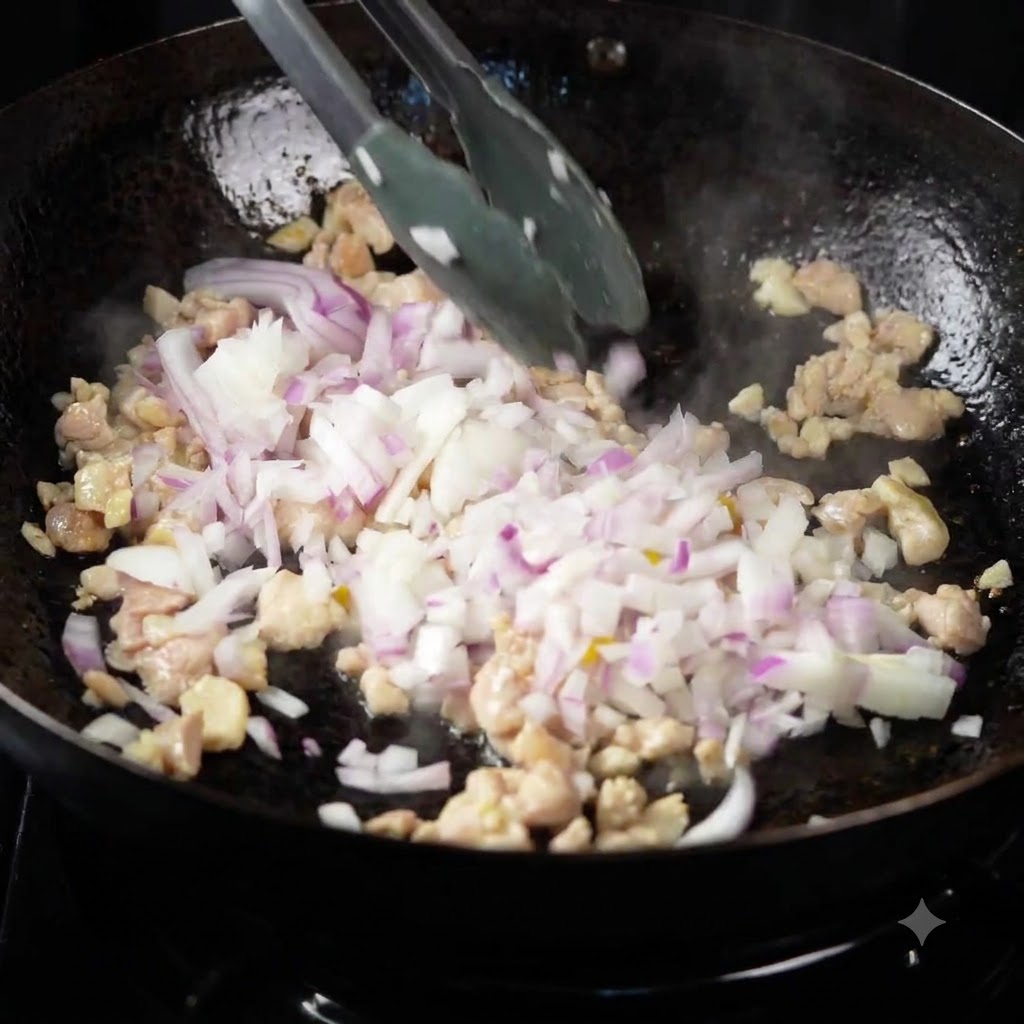 Pimientos multicolores, cebollas y calabacín siendo añadidos al pollo que se saltea en un wok.