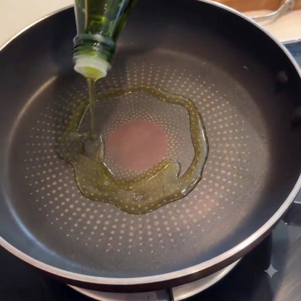 Tocino chisporroteando en una sartén con aceite de oliva cubriendo el fondo.
