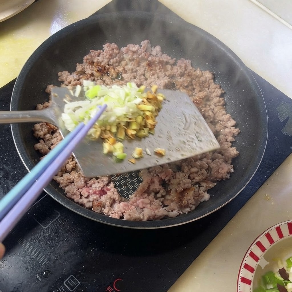 Cebollinos y jengibre picados añadidos a la carne de cerdo cocinada en una sartén.