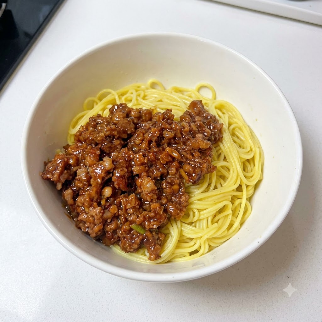 Un bol que contiene fideos y salsa de carne picada adornados con cebollinos recién picados.