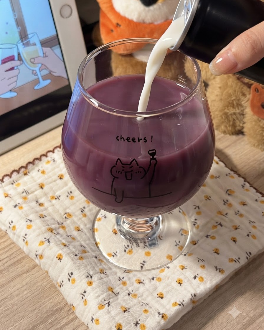 Leche blanca vertiéndose en un vaso lleno de zumo de uva morado, creando una mezcla cremosa y morada.