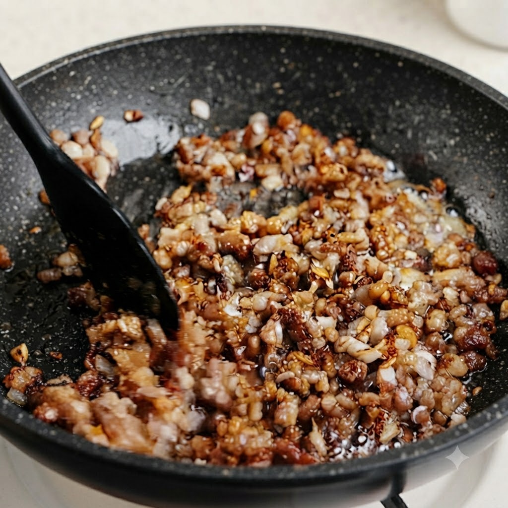 Tallos picados de cebollino verde y cebolla de verdeo mezclados en una sartén a fuego lento de carne picada sazonada.