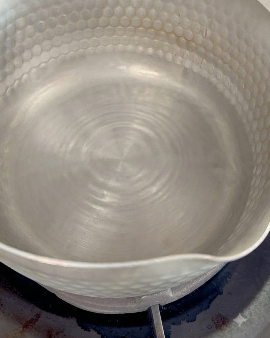 Copos de bonito seco hirviendo en una olla pequeña con agua a fuego lento para crear un sabroso caldo dashi.