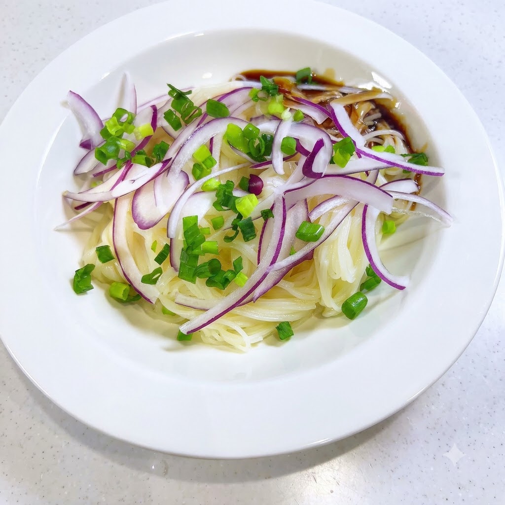 Salsa oscura y sabrosa vertiéndose en el lateral de los fideos somen y los ingredientes de cebolla en un bol blanco.