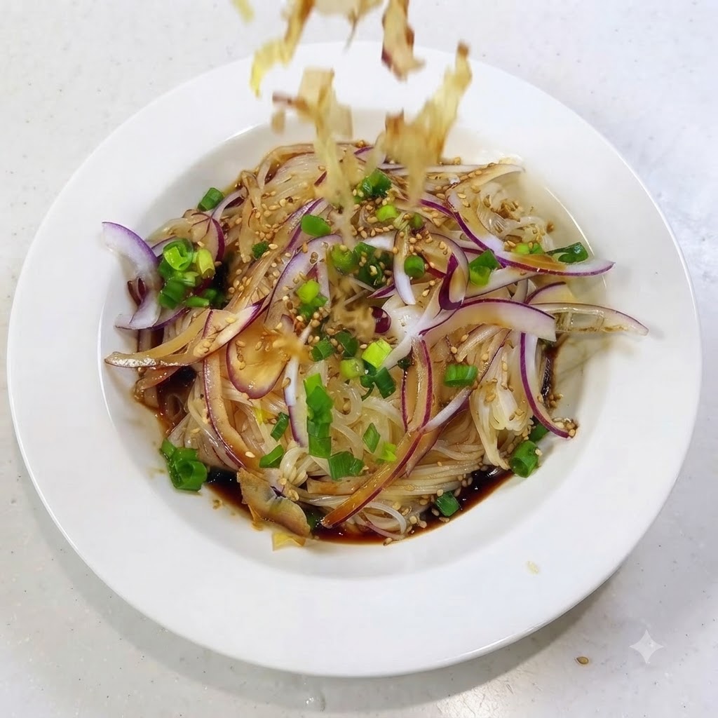 Copos de bonito cayendo y esparciéndose sobre la parte superior del plato de fideos preparado.