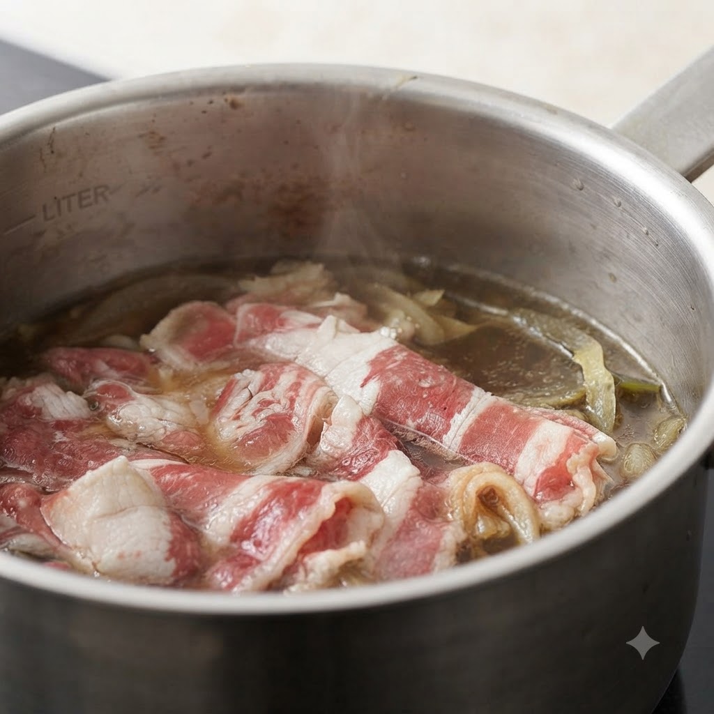 Jengibre picado siendo añadido a una olla que contiene trozos de ternera y cebollas en un caldo a fuego lento.