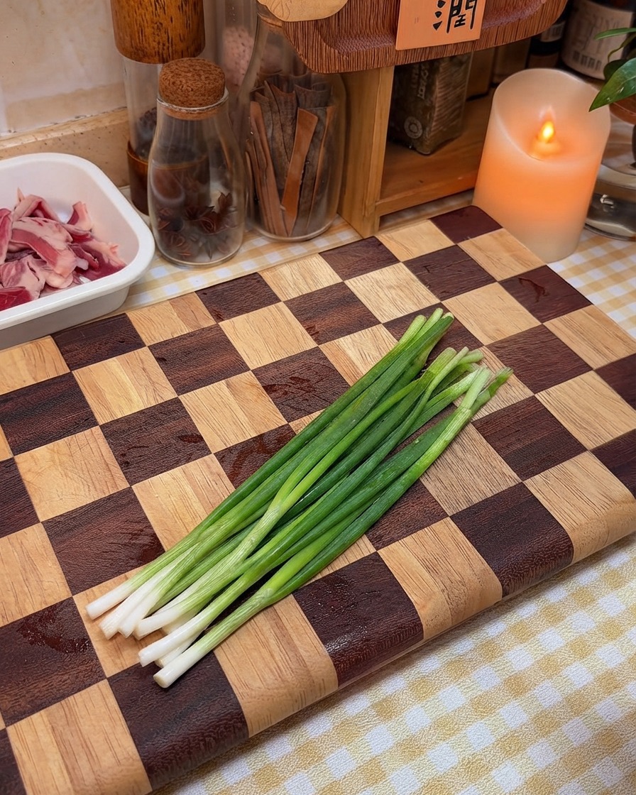 Cebolletas frescas preparadas y listas para ser picadas en una tabla de madera.