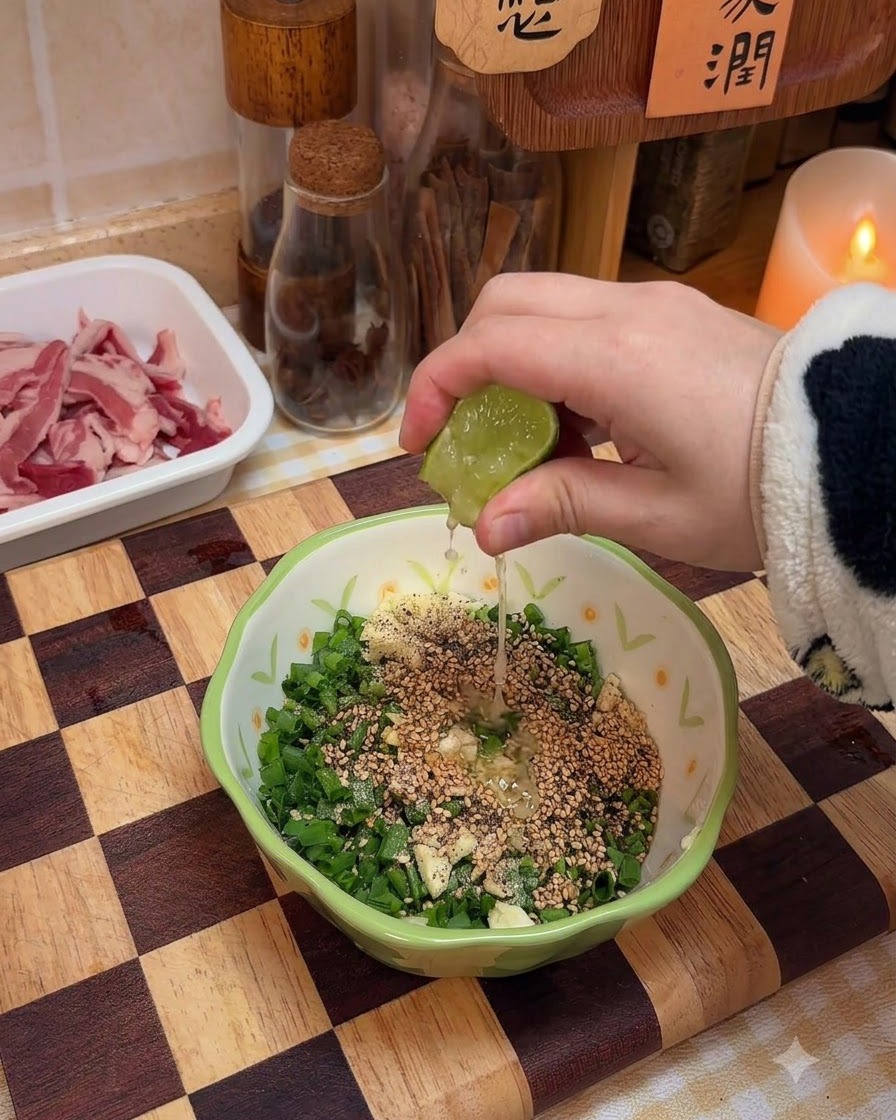 Jugo de lima fresca siendo exprimido en el cuenco con los ingredientes de la salsa de cebolleta.