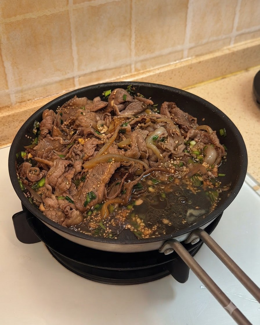 Dos huevos cascados en la sartén junto a la ternera cocida y las cebollas en su salsa.