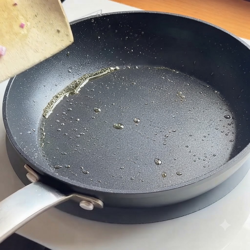 Cebollas moradas picadas friéndose en una sartén caliente con aceite.
