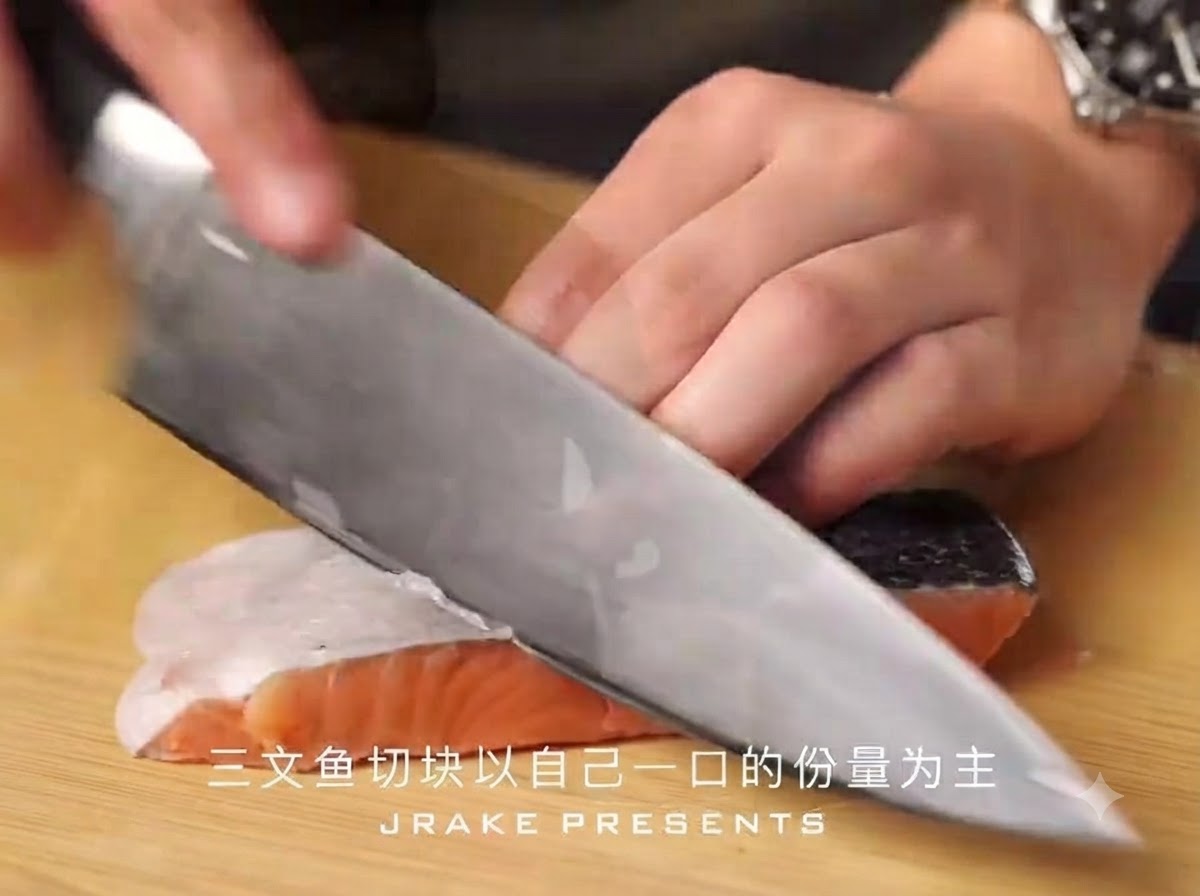 Un cuchillo de chef afilado cortando un filete de salmón con piel en trozos pequeños sobre una tabla de cortar de madera.