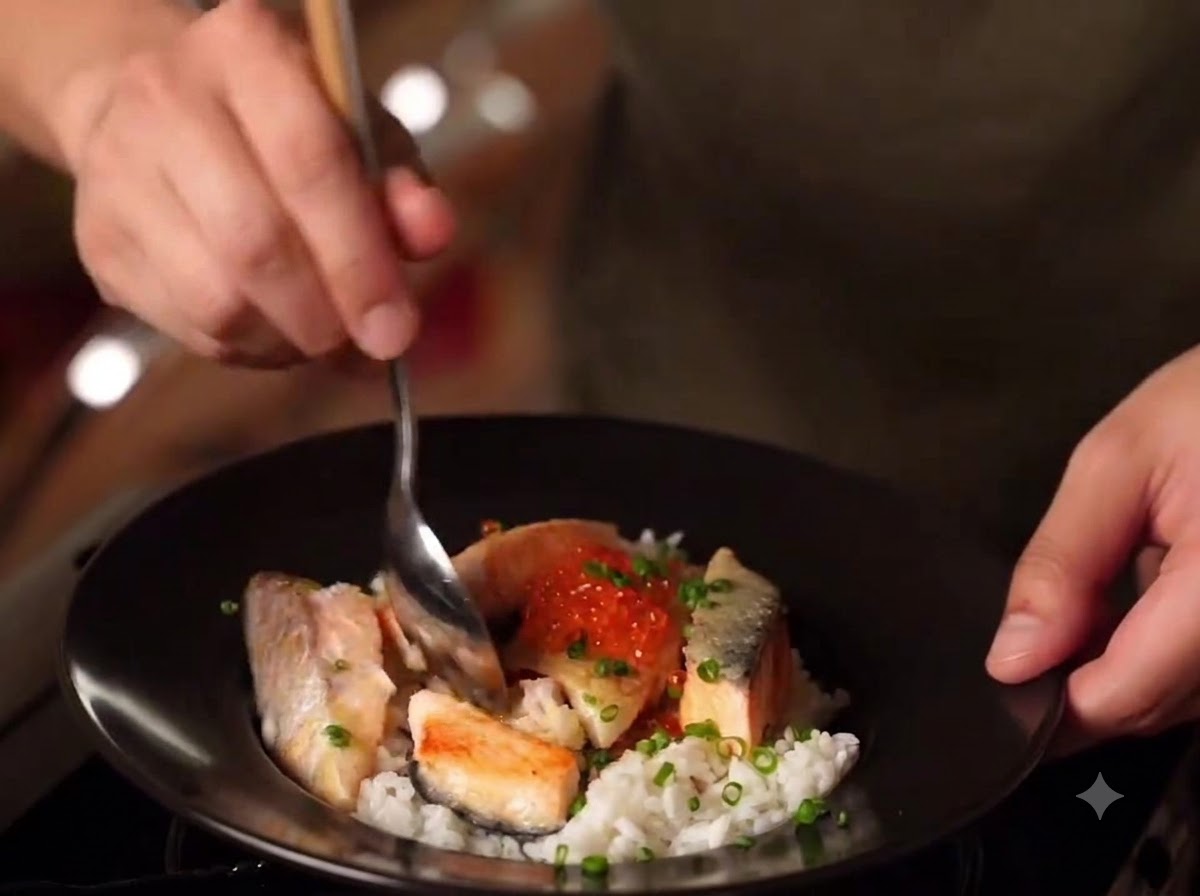 Un primer plano de un plato terminado de Oyakodon de Salmón al Miso con arroz, salmón sellado, huevas de salmón y cebollinos.
