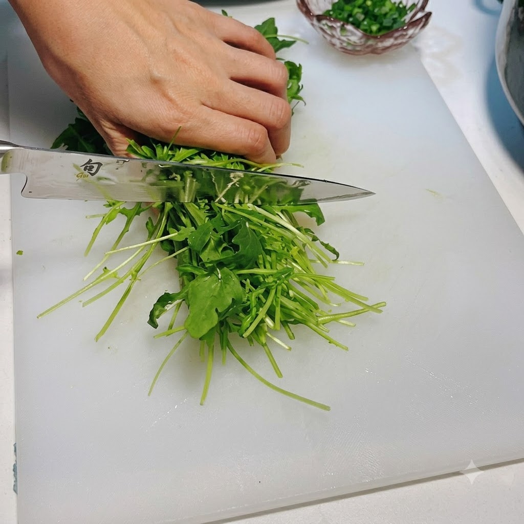 Rúcula verde fresca siendo cortada con un cuchillo en una tabla de cortar blanca.
