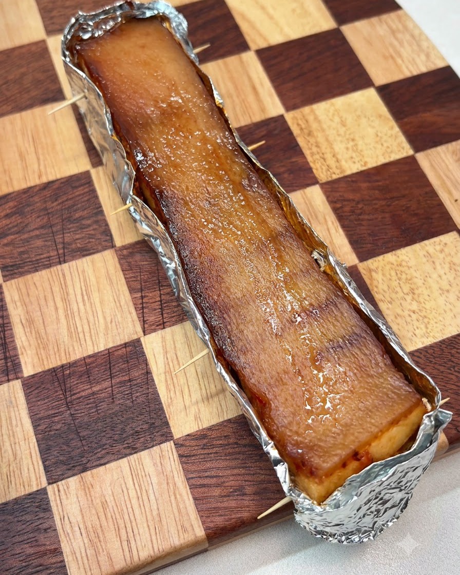 Una capa gruesa de sal gruesa extendida uniformemente sobre la superficie superior de la piel del cerdo envuelta en papel de aluminio.