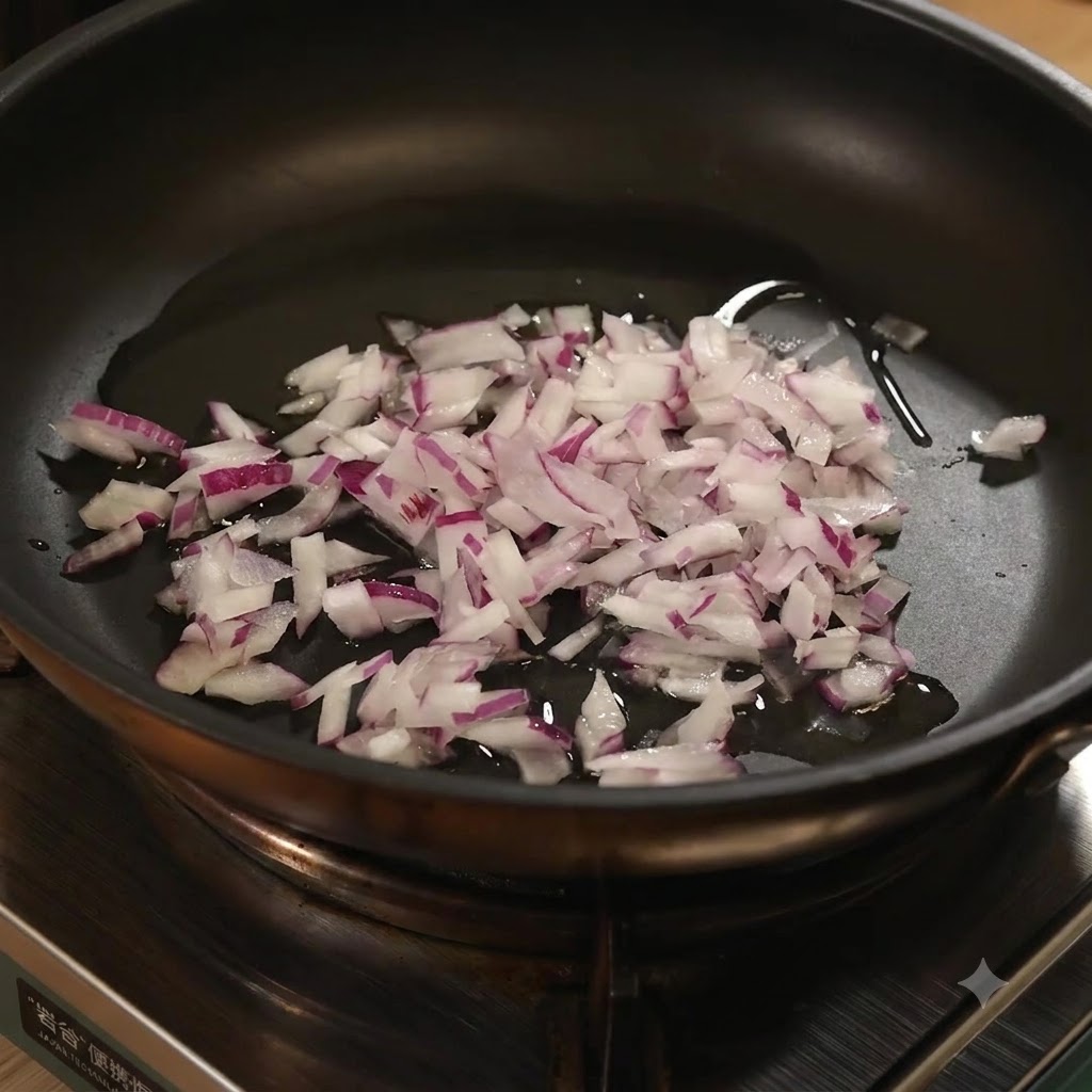 Ajo picado añadido a la sartén con cebollas rojas picadas y aceite.