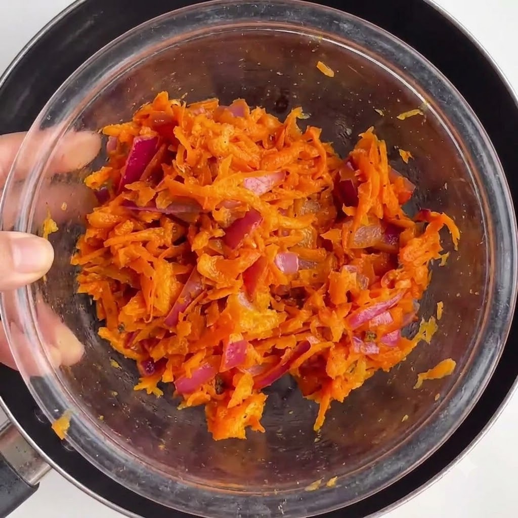 Tazón que contiene la mezcla de verduras cocidas ubicado dentro de una sartén.