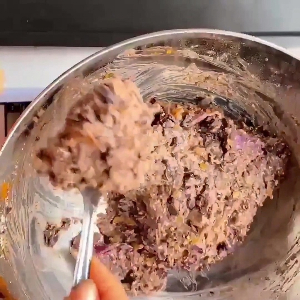 Primer plano de manos presionando y dando forma a la mezcla de frijoles negros para convertirla en una hamburguesa redonda.