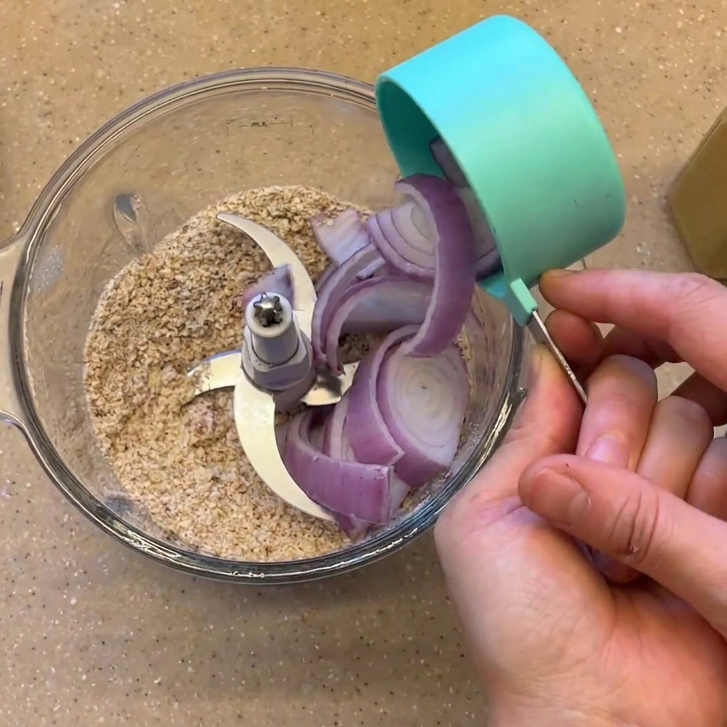 Cebolla morada en rodajas y frijoles negros cocidos siendo vertidos en el vaso de la licuadora.