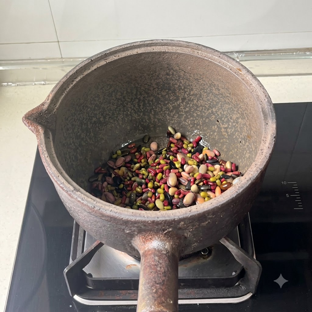 Frijoles mixtos en el fondo de una olla de barro después de haber añadido agua.