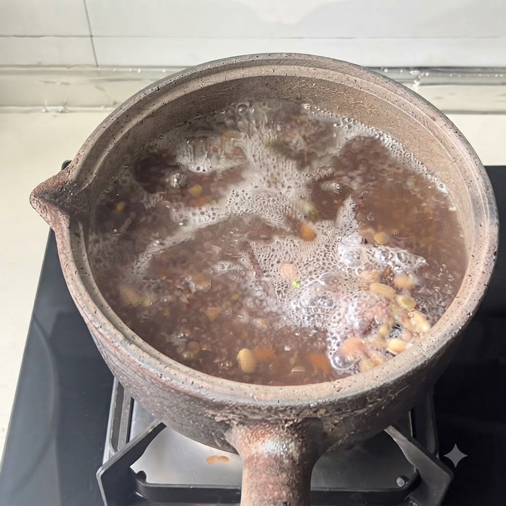Una olla de barro con su tapa puesta descansa sobre el quemador de una estufa moderna durante el proceso de cocción.