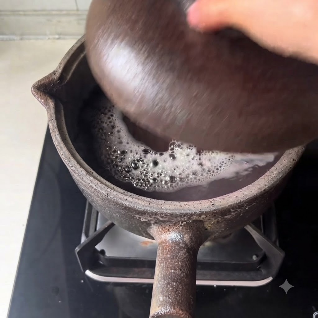 Vista de cerca del caldo oscuro hirviendo a fuego lento y los frijoles burbujeando dentro de la olla de barro.