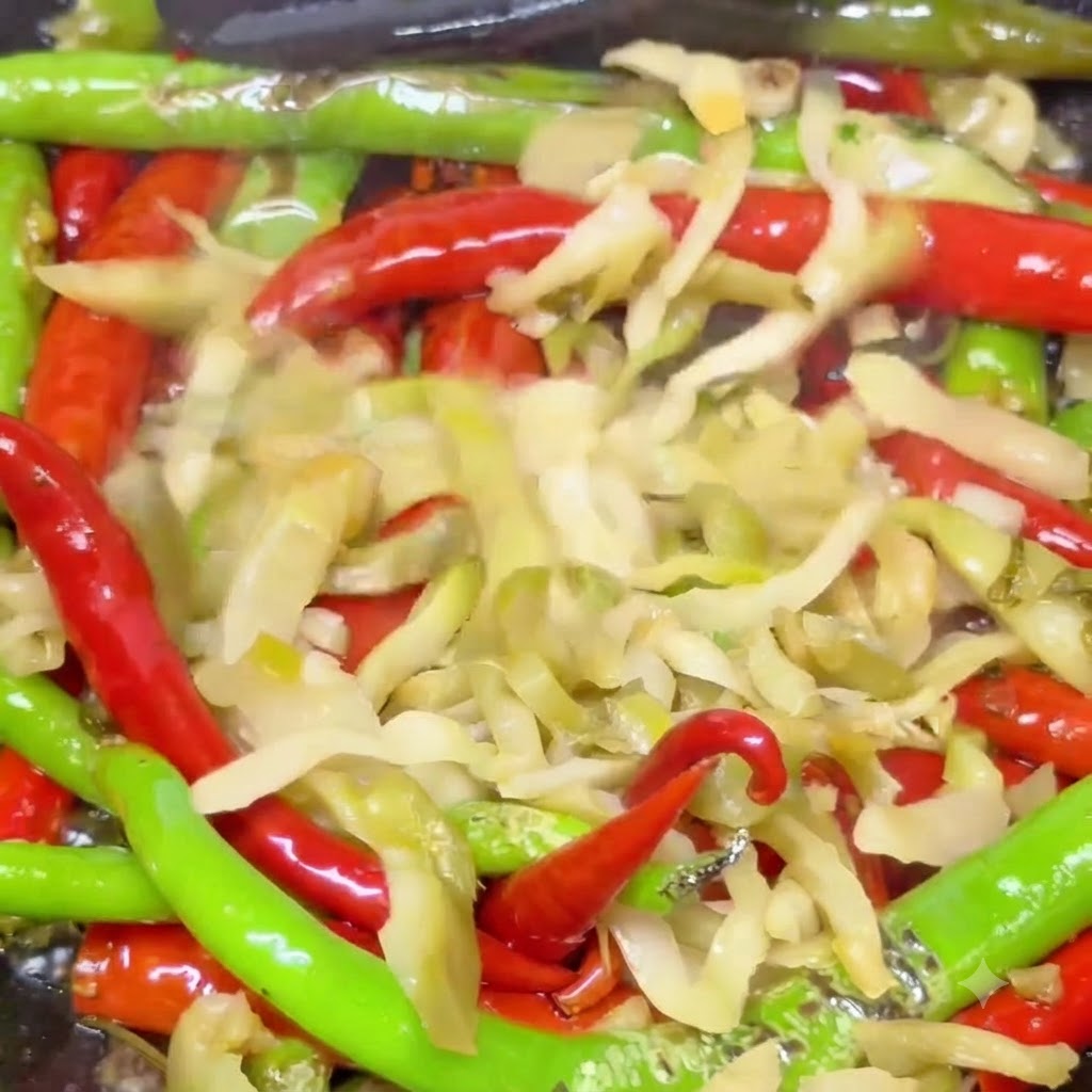 Hojas de mostaza encurtidas mezcladas con chiles rojos y verdes ampollados salteando en un wok caliente.