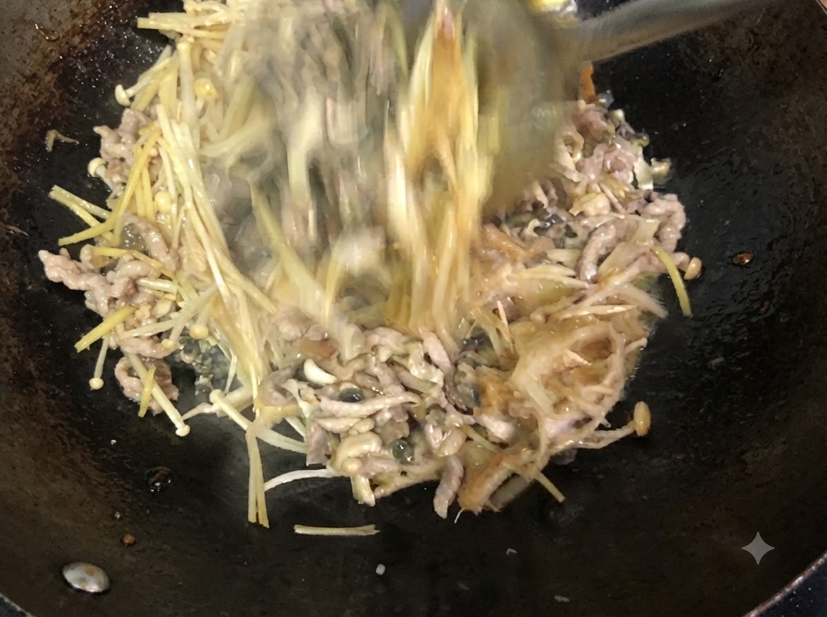 Ingredientes siendo revueltos y mezclados activamente en el wok con una espátula de metal.