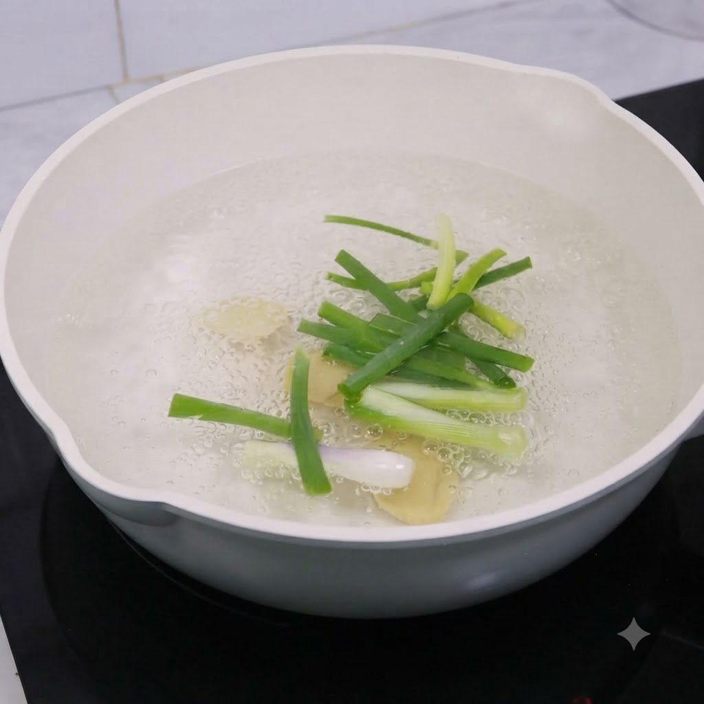 Rodajas de jengibre y cebolletas hirviendo en una olla con agua y vino de cocina.