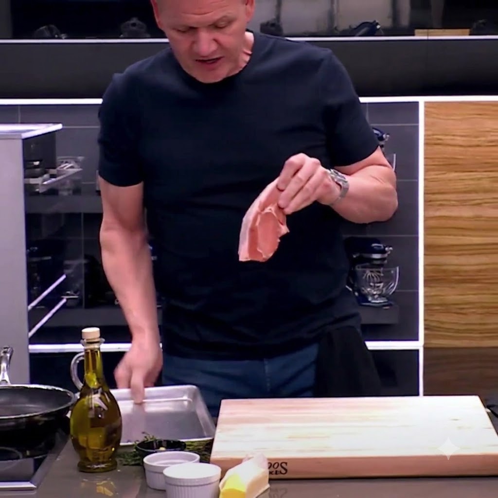 Un par de tijeras de cocina recortando tiras de grasa de una chuleta de cerdo sobre una tabla de cortar de madera.