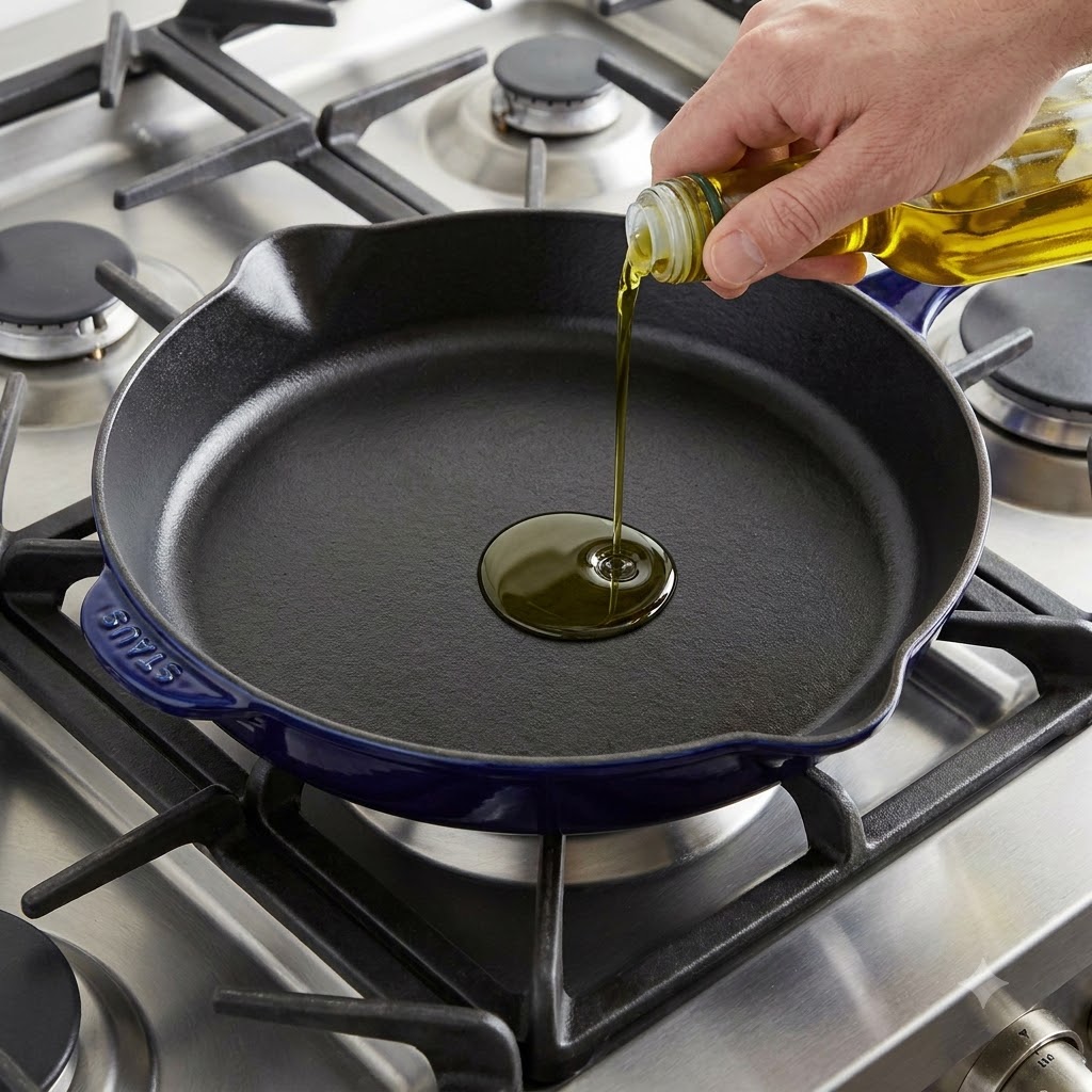 Aceite de oliva siendo vertido en una sartén de hierro fundido precalentada.