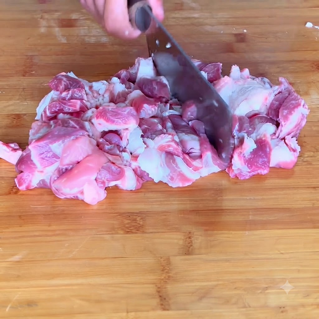 Primer plano de cerdo picándose en una pasta de carne fina sobre una tabla de cortar.