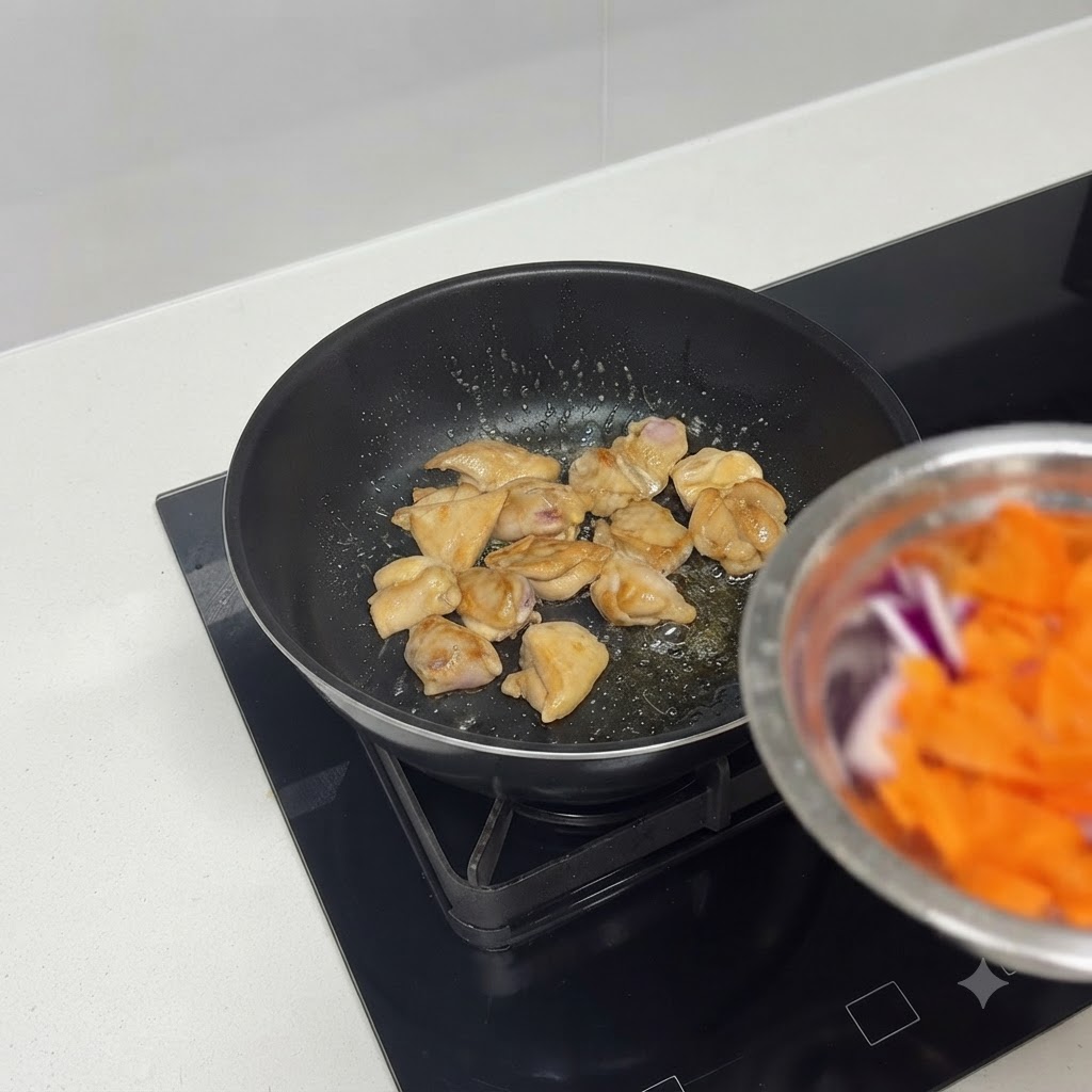 Trozos de pollo dorándose agradablemente en una sartén.