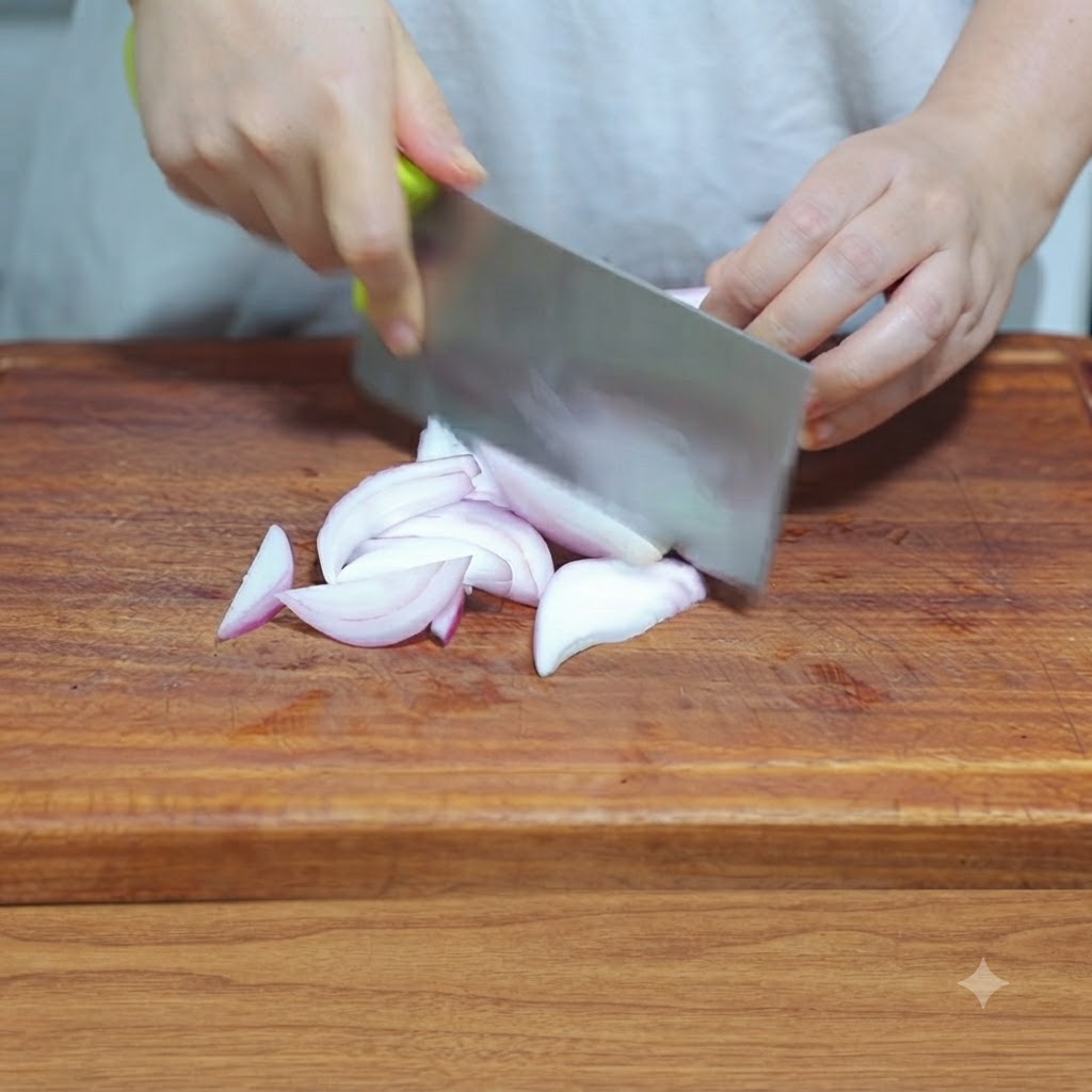 Un cuchillo de cocina cortando una cebolla en rodajas finas sobre una tabla de cortar de madera.