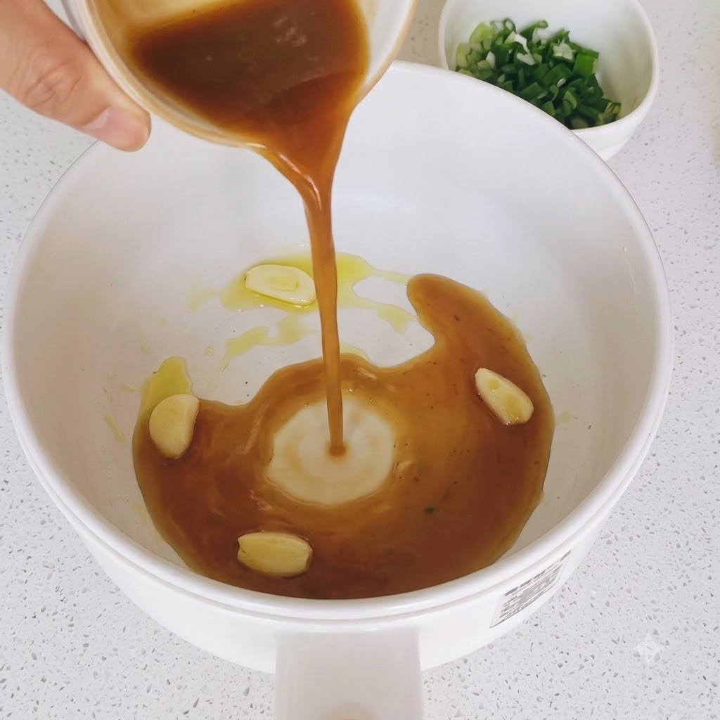 Mezcla de salsa marrón siendo vertida en una sartén con rodajas de ajo salteadas.