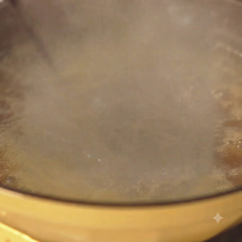 Espaguetis hirviendo vigorosamente en una olla amarilla con agua y vapor elevándose.