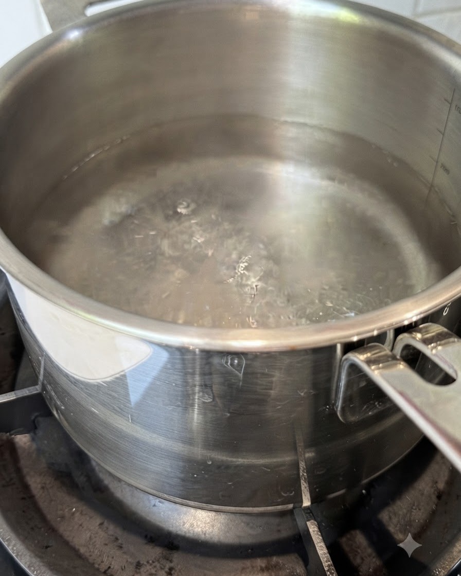 Fideos de espaguetis secos sumergiéndose en una olla con agua hirviendo.