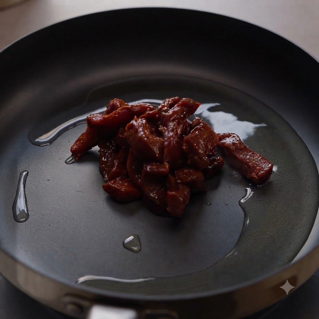 Trozo de carne marinada chisporroteando en el centro de una sartén caliente cubierta con aceite de cocina.