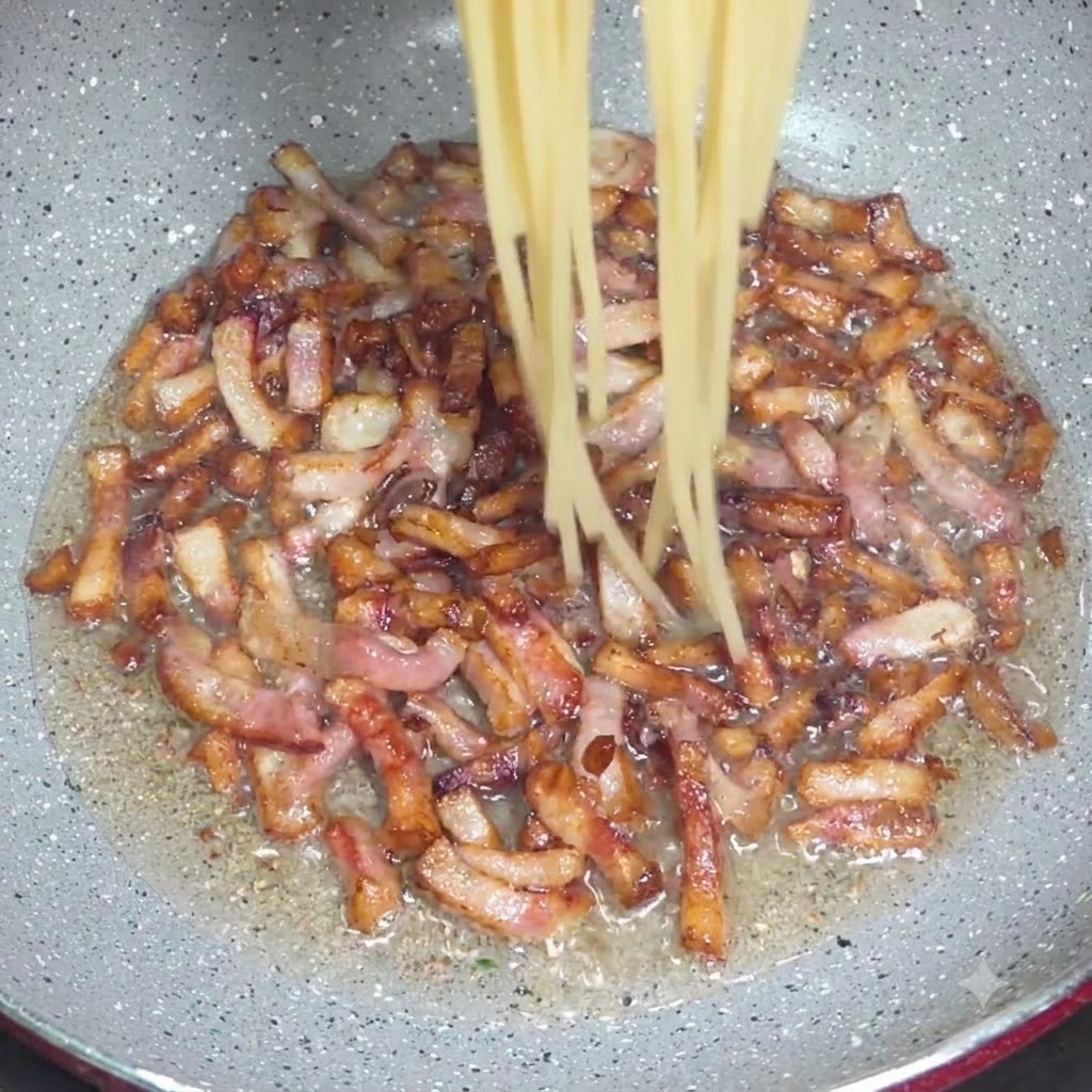 Fideos de espagueti cocidos cayendo desde unas pinzas a una sartén con trozos de guanciale crujiente.