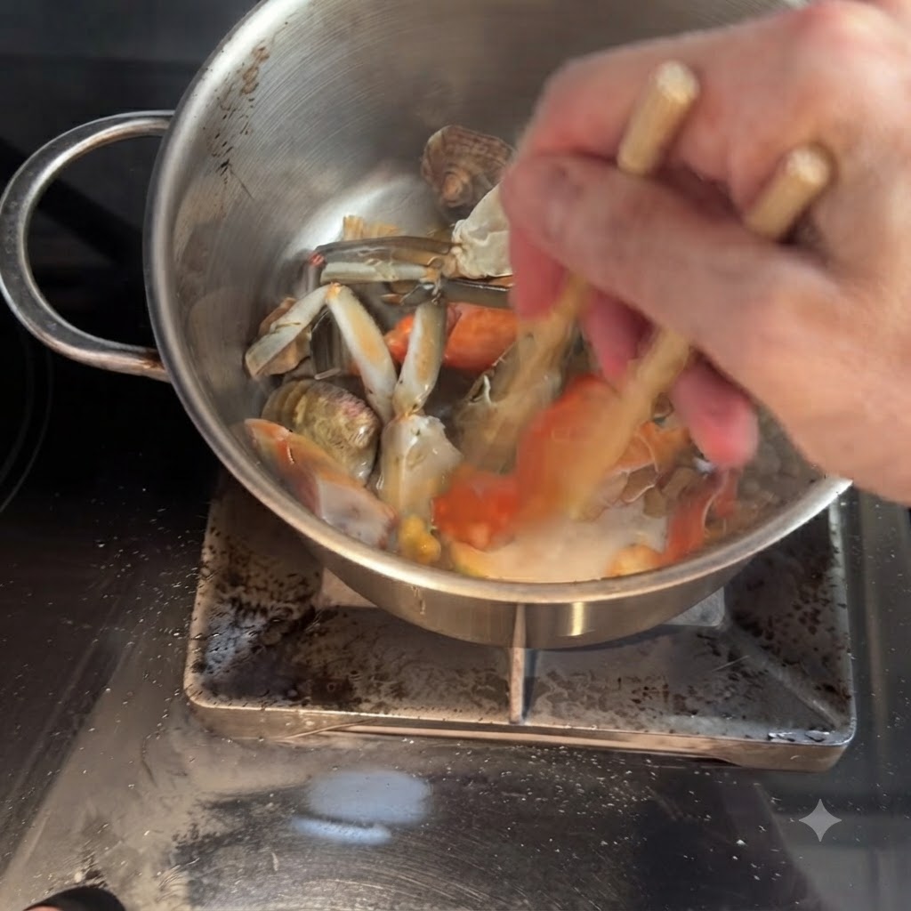 Carne de cangrejo y langostinos grandes siendo salteados en la olla usando palillos.