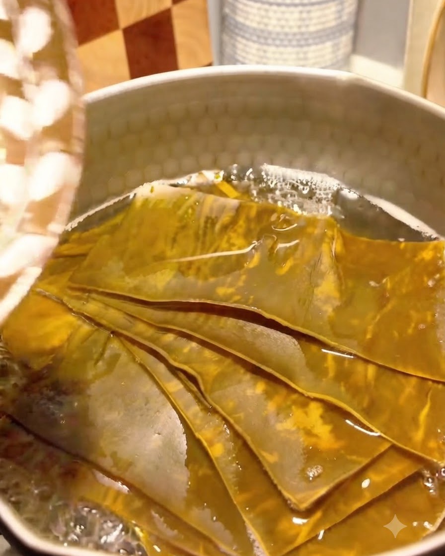 Copos de bonito añadiéndose al caldo de kelp hirviendo a fuego lento.