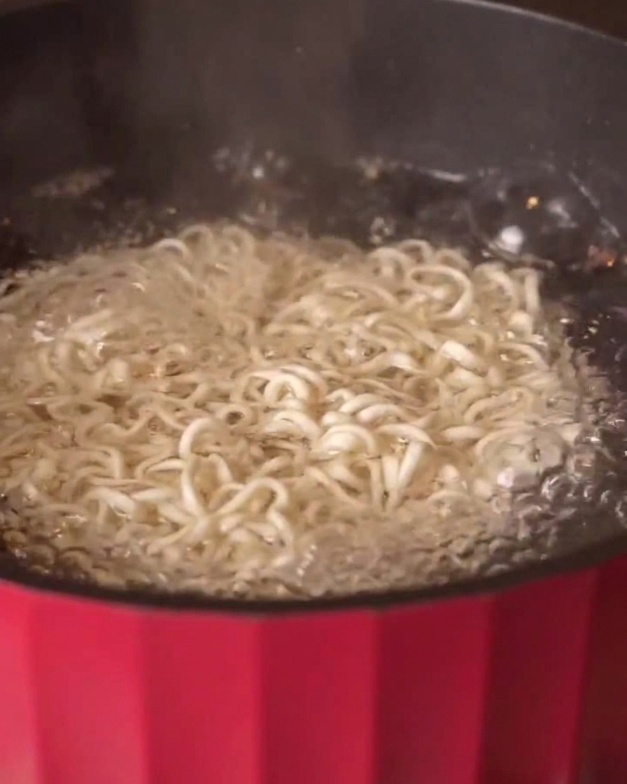 Fideos multigrano hirviendo en una olla con agua caliente.