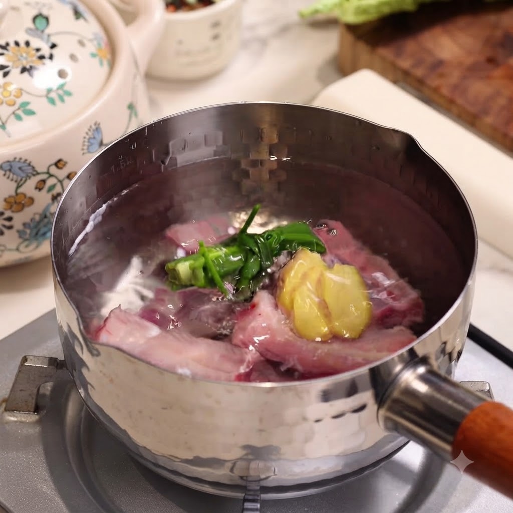 Costillas de cerdo crudas hirviendo en una olla de acero inoxidable con cebolletas y rodajas de jengibre.