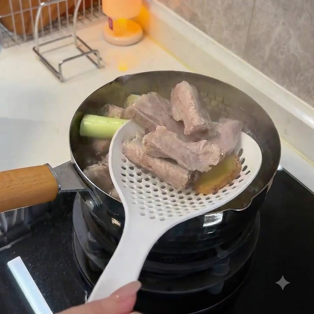 Usando una cuchara ranurada blanca para levantar costillas de cerdo blanqueadas y opacas y rodajas de jengibre fuera del agua hirviendo.