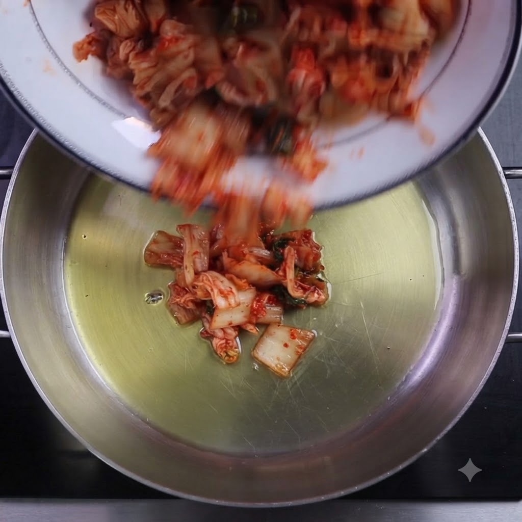 Kimchi picado y chile en polvo siendo vertidos en una olla de cocción aceitada.
